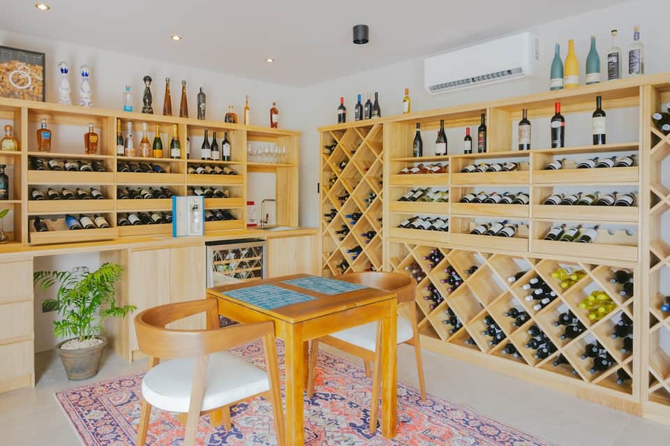 Wine tasting room with extensive wooden wine racks, bottles, and tasting table