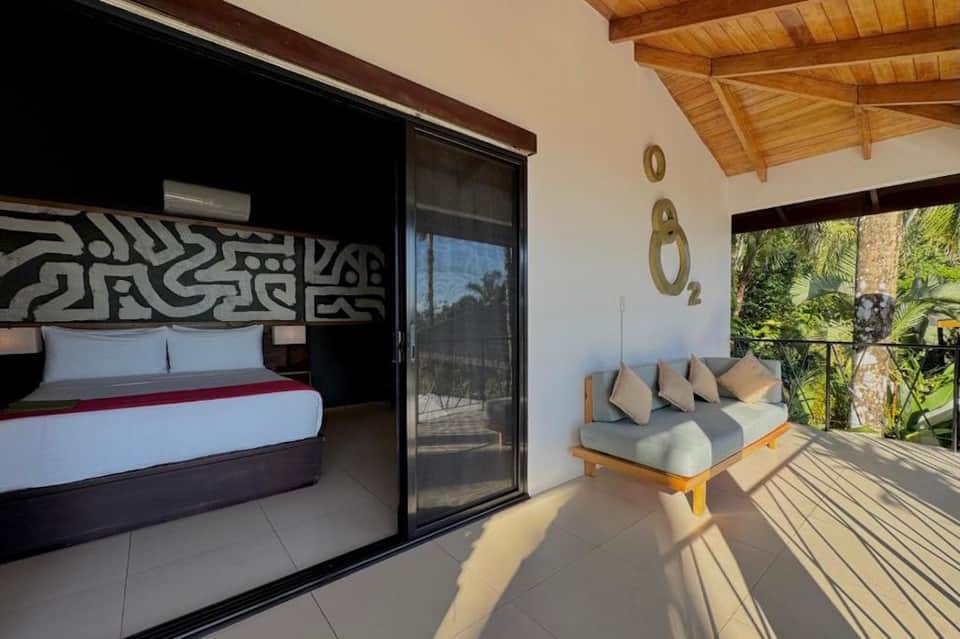 Modern resort bedroom with black accent wall, ocean balcony view
