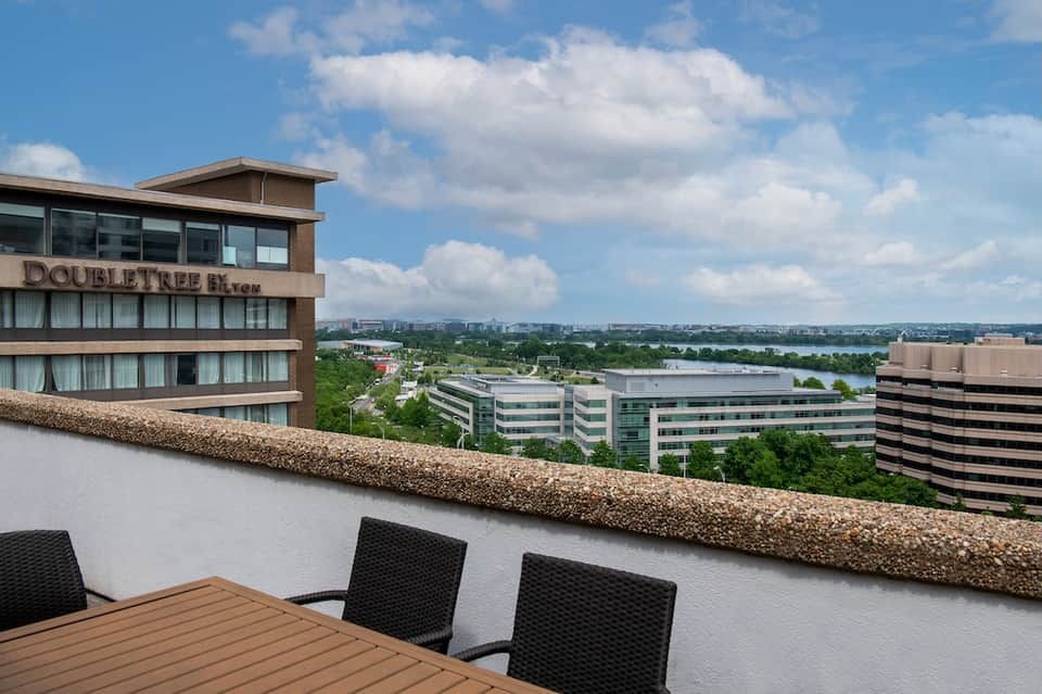 Rooftop terrace view of DoubleTree hotel overlooking river, cityscape, and green landscape