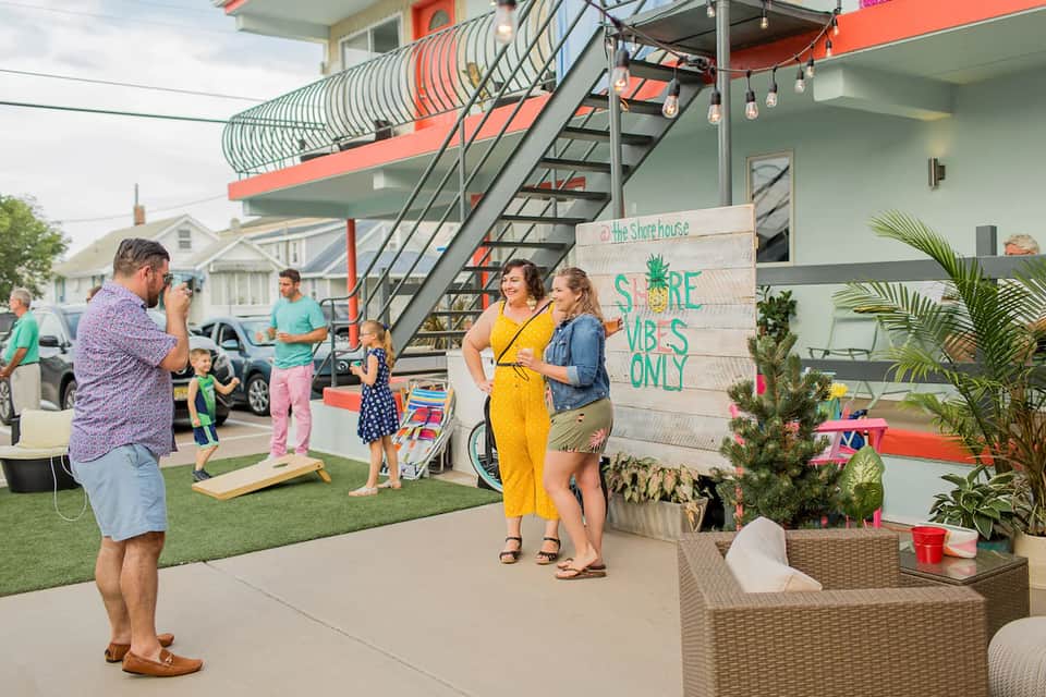 Family gathering outside colorful beachfront property with orange and green architectural features