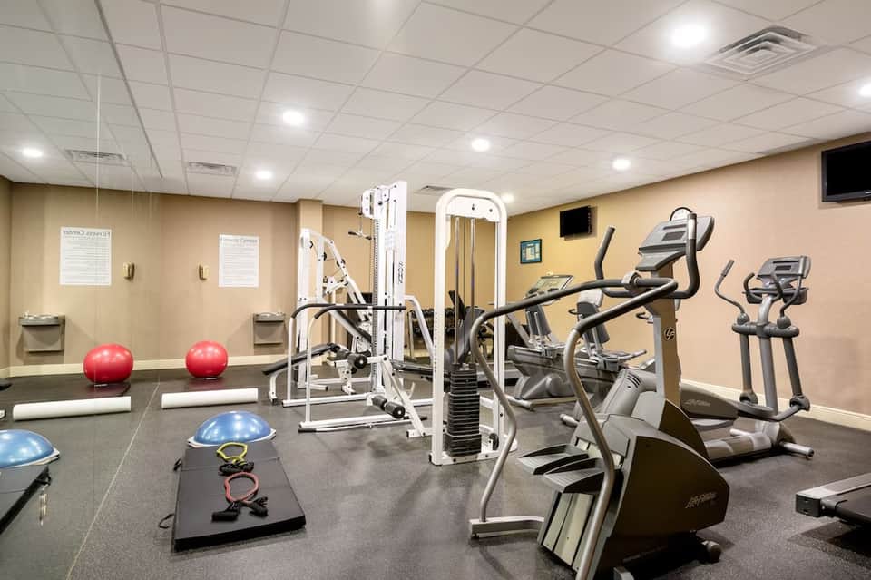 Full-service fitness center with cardio equipment, weight machines, and exercise balls