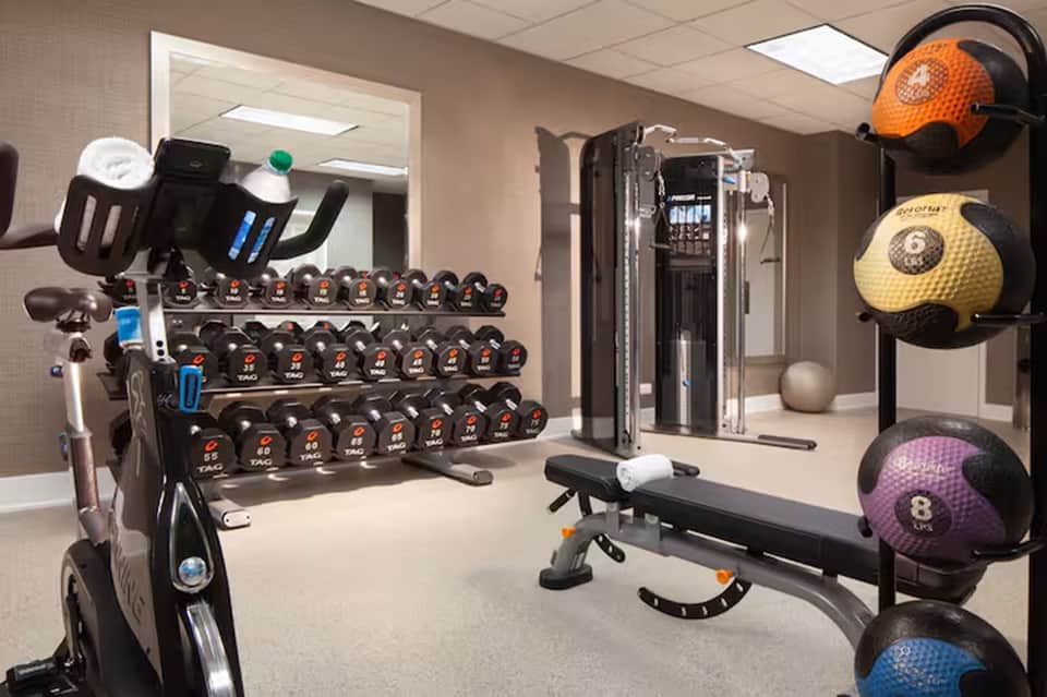 Fitness center with dumbbell rack, exercise bike, medicine balls, and weight training equipment