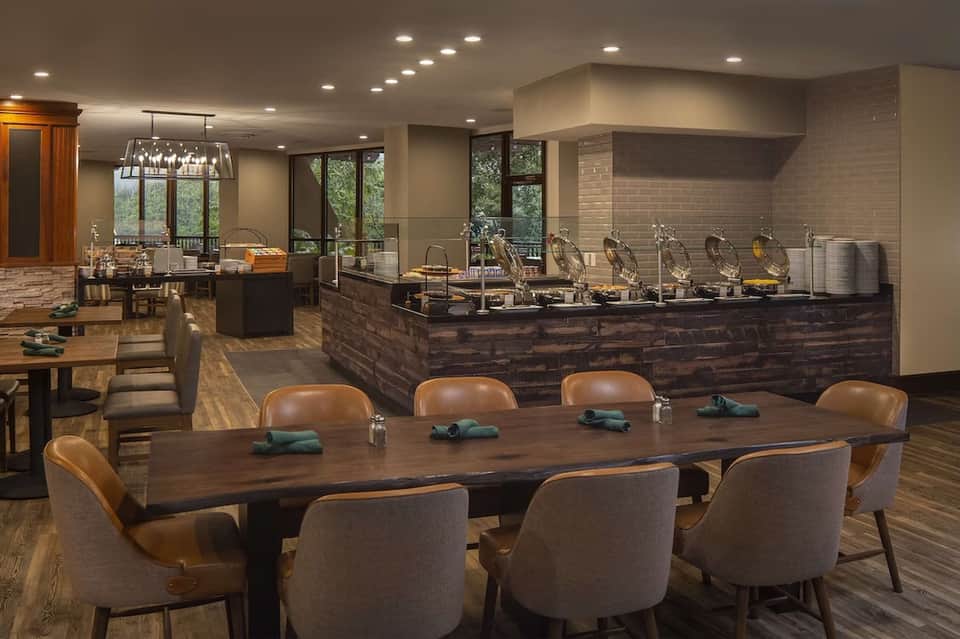 Executive lounge and breakfast buffet with serving stations, dining table, and nature views