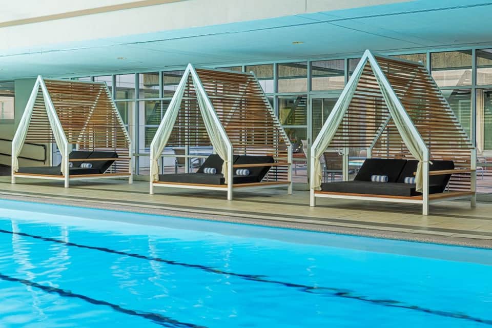 Indoor pool with modern white cabanas and lap lanes