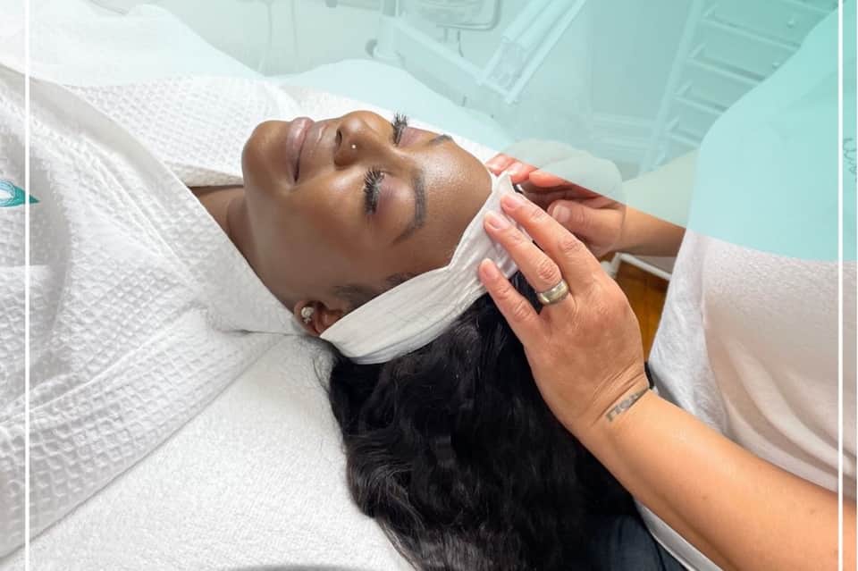 Spa facial treatment with therapist applying mask to relaxed client's face