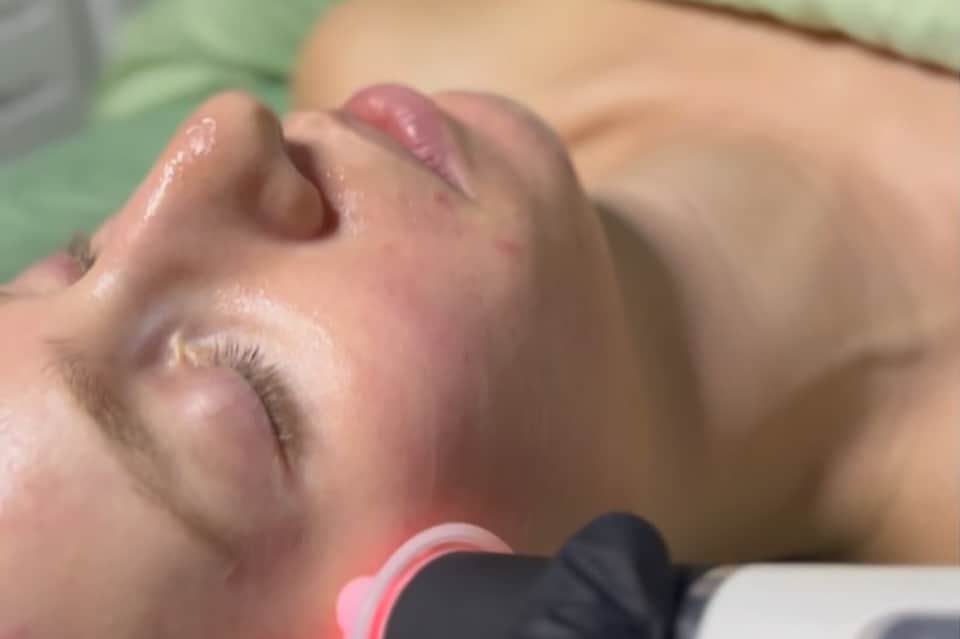 Close-up of relaxed person receiving facial spa treatment at wellness resort