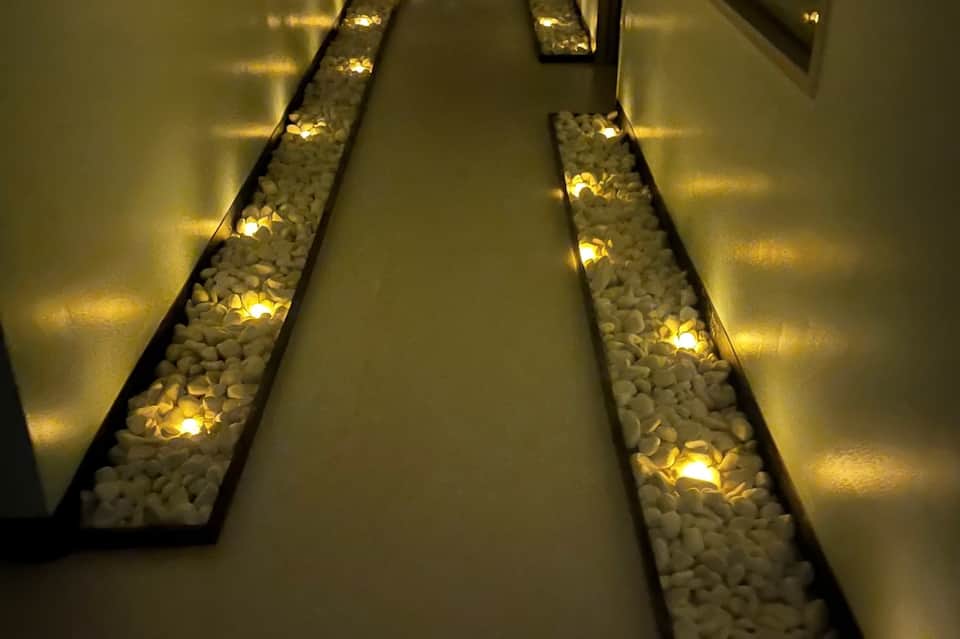 Illuminated hallway with decorative white stone features and warm accent lighting in hotel corridor