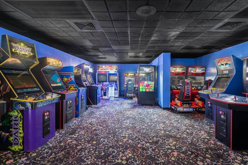 Vintage arcade game room with classic colorful gaming machines and patterned carpet flooring