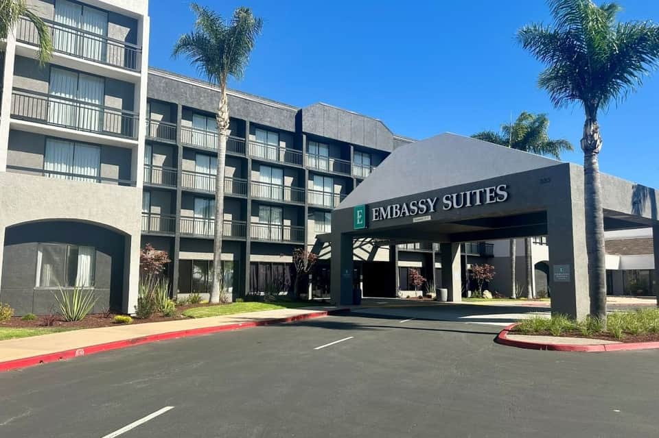 Embassy Suites hotel exterior showing modern concrete and glass facade with porte-cochere entrance