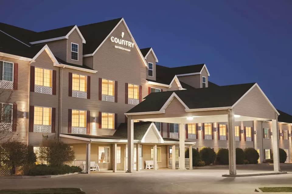 Country Inn hotel exterior at dusk with illuminated windows and traditional architecture