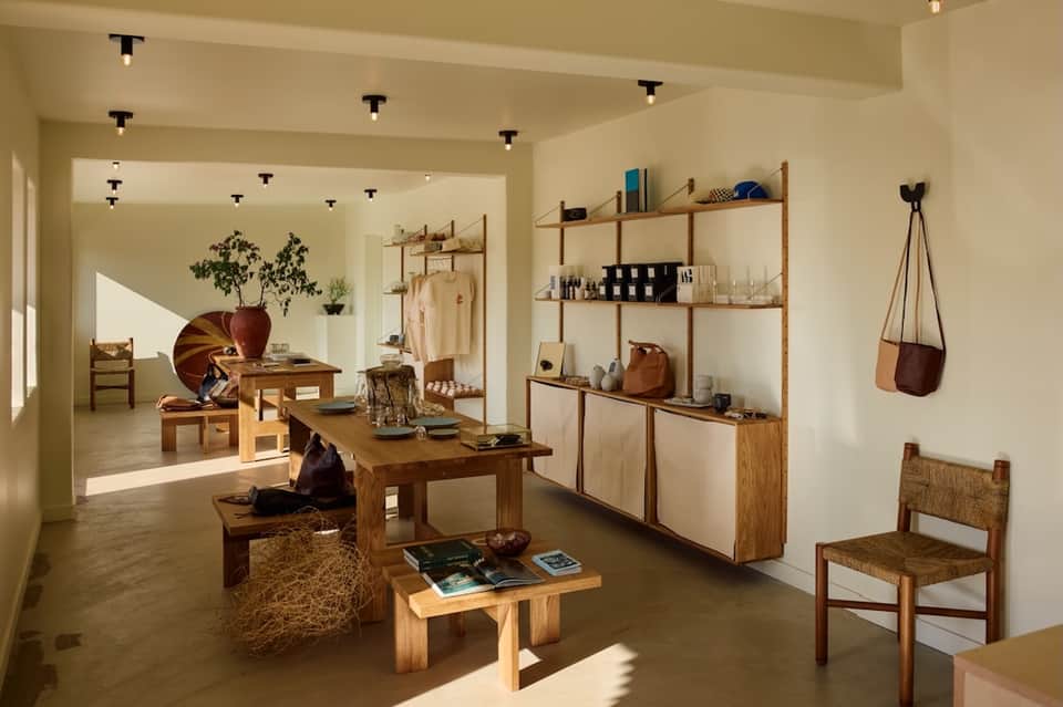 Modern wellness retail boutique with wooden shelving, natural light, and minimalist design