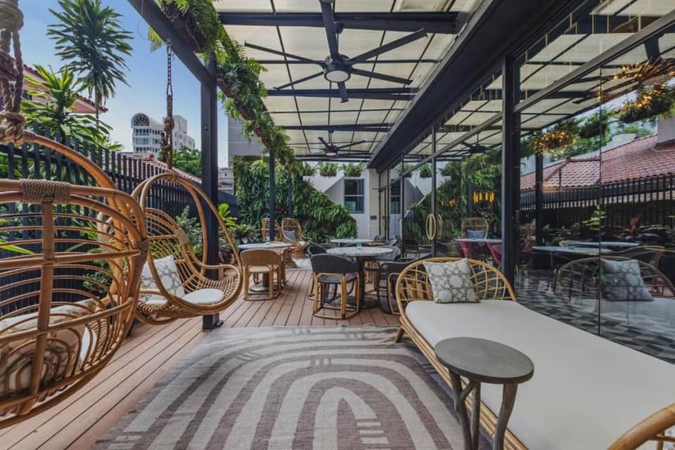 Rooftop terrace with wicker chairs, vertical gardens, and city skyline views