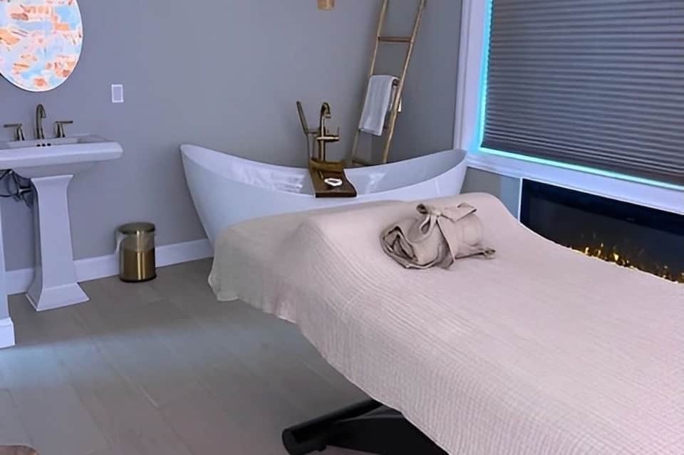 Contemporary bedroom with freestanding soaker tub, fireplace and modern amenities