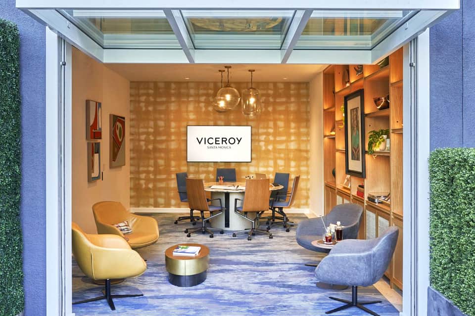 Modern office space with glass ceiling, warm wood walls, pendant lighting, and contemporary furniture
