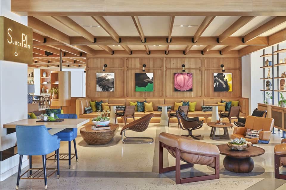 Modern hotel lobby lounge with wood ceiling beams, colorful seating, and contemporary artwork