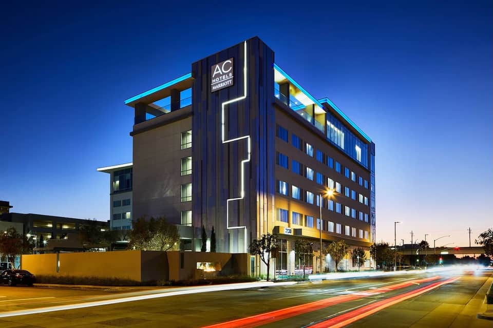 Contemporary AC Hotel Marriott building at dusk with illuminated blue and yellow architectural accents
