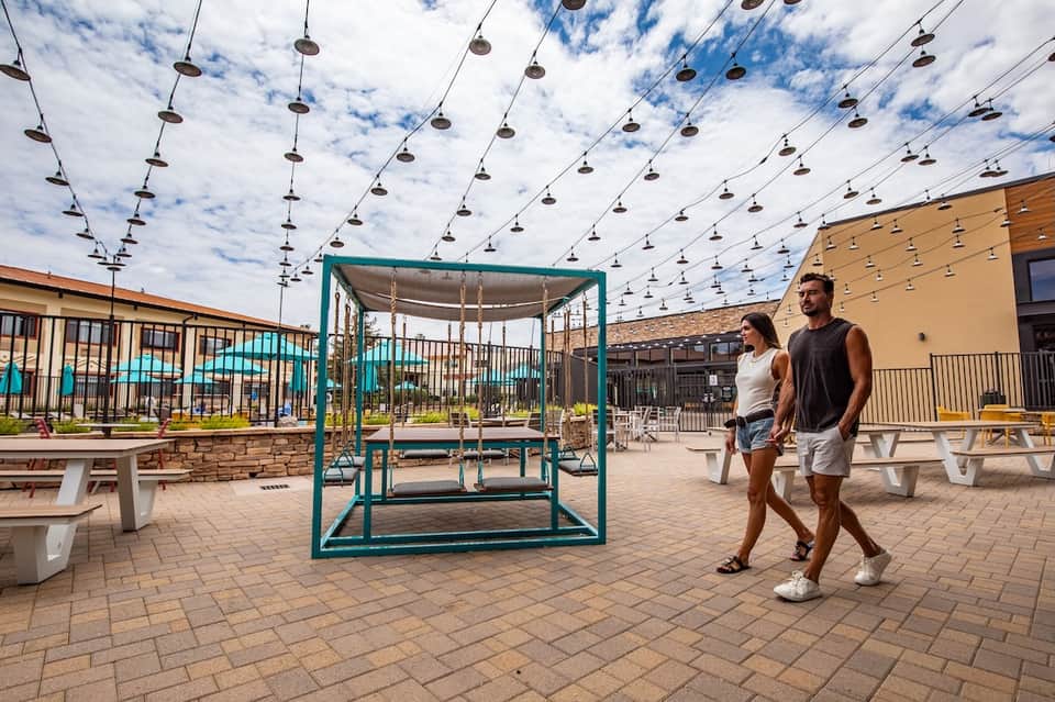 Outdoor recreation area with hanging shoes art installation and covered swing structure