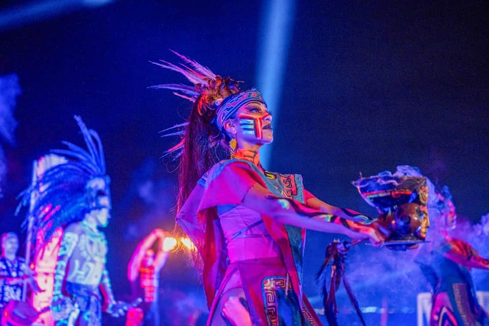 Colorful theatrical performer in vibrant costume under stage lighting during nighttime show