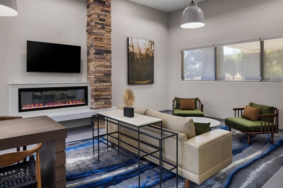 Modern hotel lounge with fireplace, cream seating, and contemporary furnishings