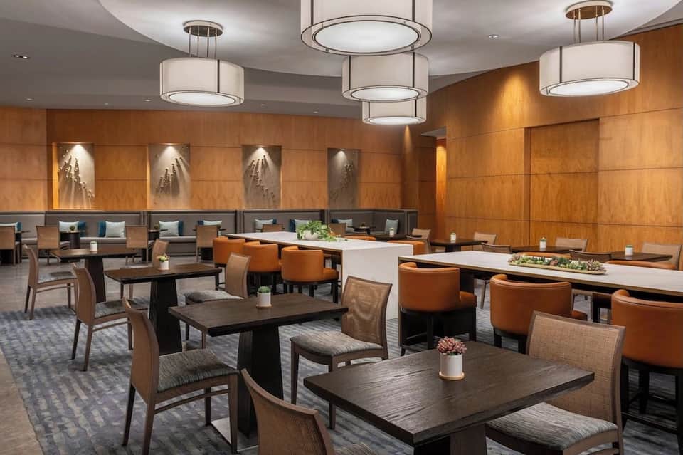 Elegant lounge with wood paneling, comfortable seating, pendant lights, and modern design