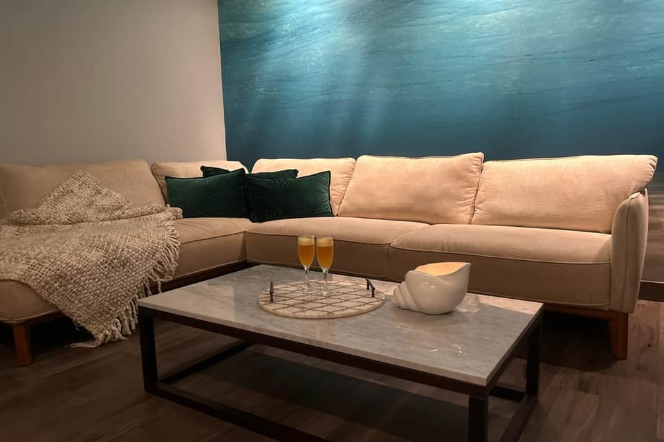 Hotel suite living area with cream sectional sofa, decorative pillows, and modern table