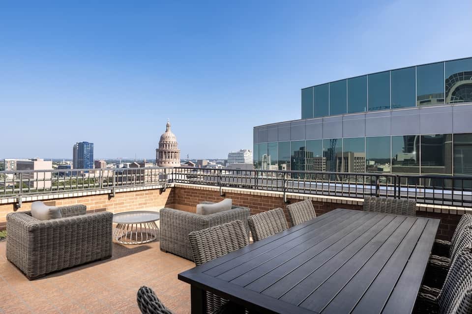 Upscale rooftop terrace with city views of capitol building and wicker furniture
