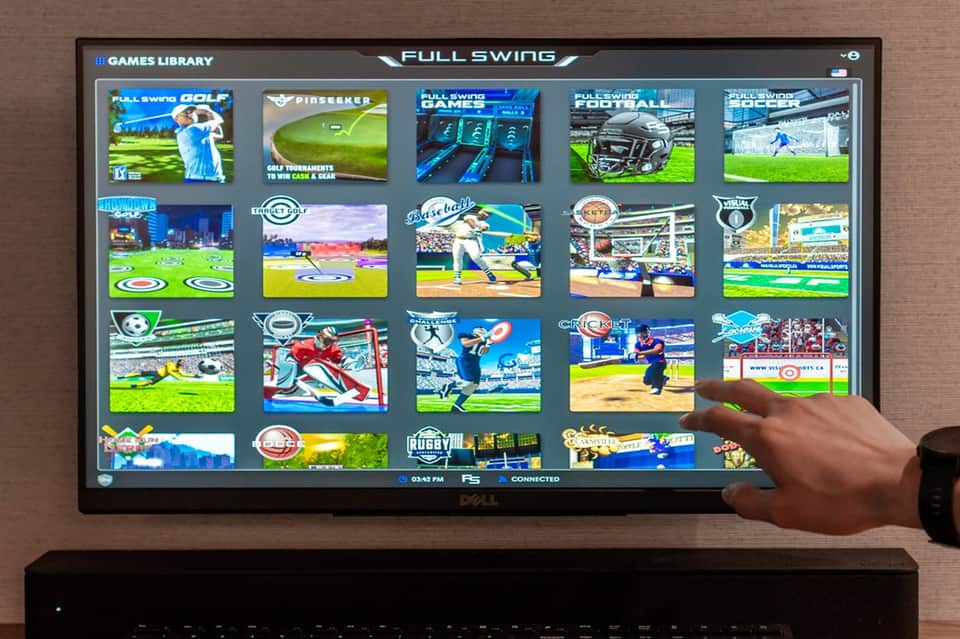 Interactive sports game console display showing Full Swing golf and multi-sport entertainment options