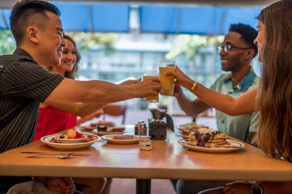 Guests dining together at a restaurant table with city views