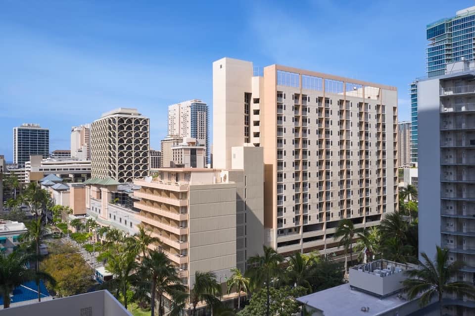 Urban hotel exterior with beige and tan multi-story building among other downtown high-rises
