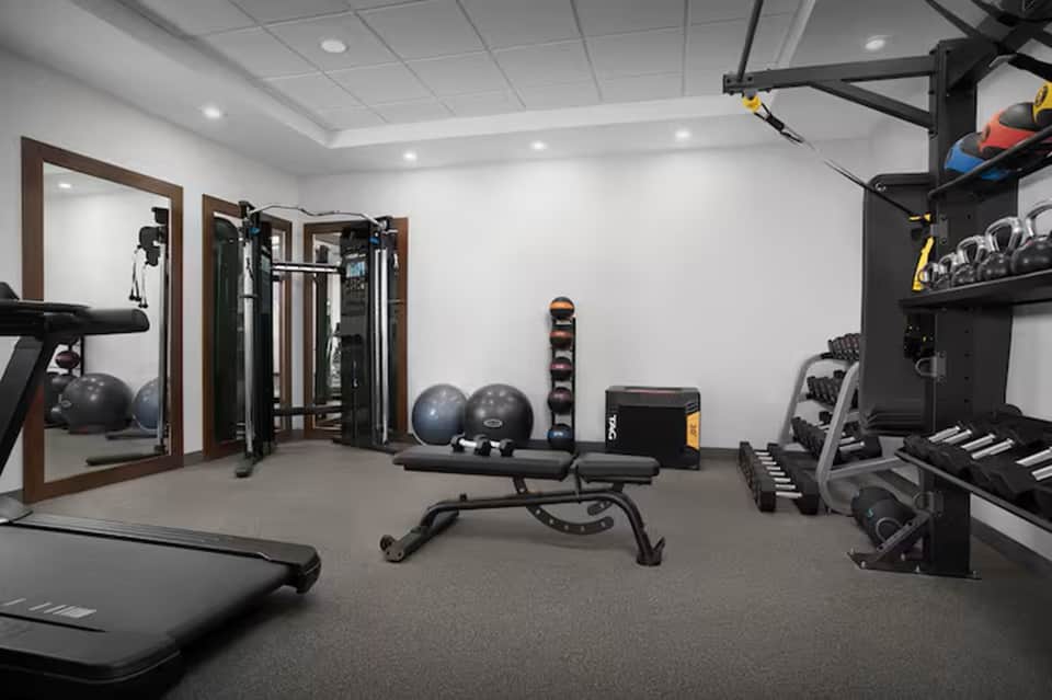 Home fitness room with treadmill, weight equipment, and resistance machines