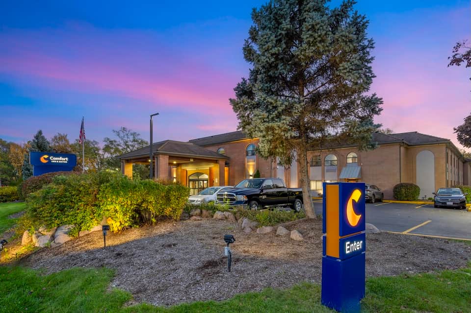Comfort Inn hotel exterior at dusk with brick facade, landscaping, and illuminated entrance