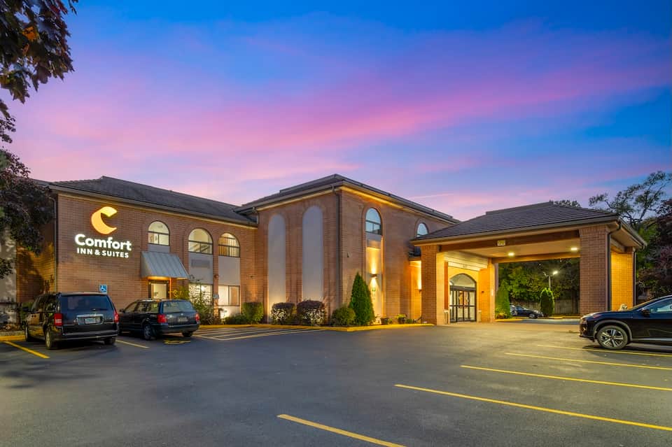 Comfort Inn & Suites brick building exterior with illuminated entrance and parking lot at dusk