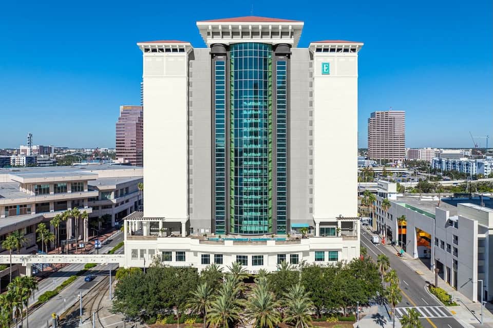 Contemporary Hilton hotel tower with distinctive green glass center and white stone facade
