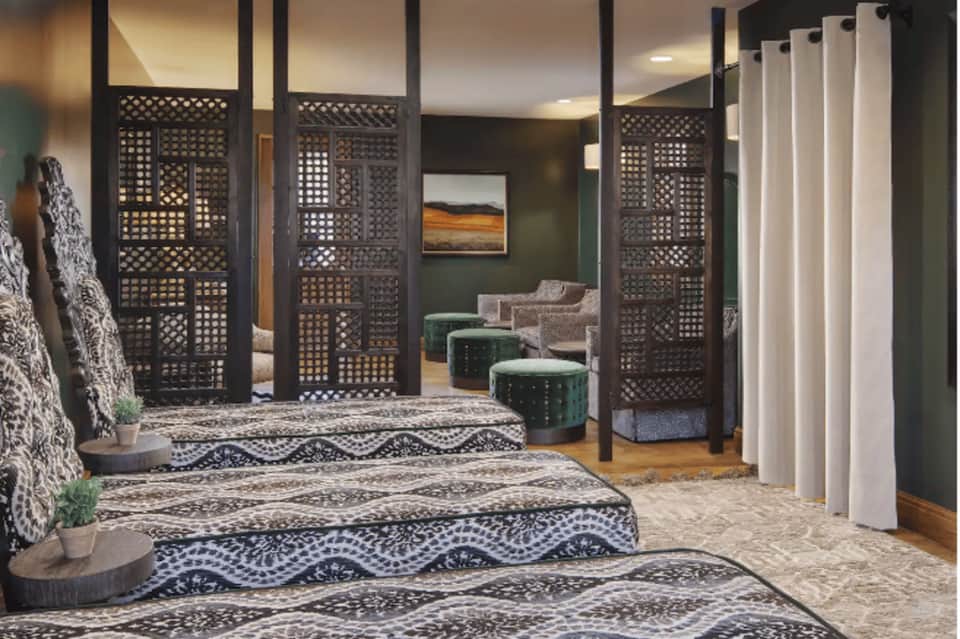 Spa relaxation lounge with decorative room dividers, comfortable seating, and welcoming entry