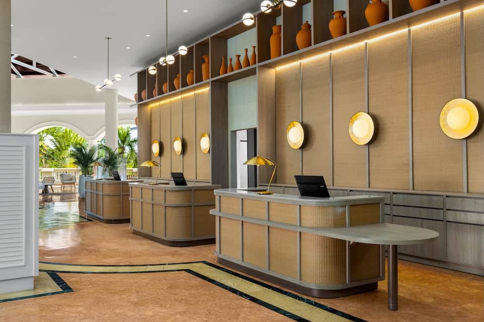 Modern hotel reception desk with textured walls and circular lighting fixtures