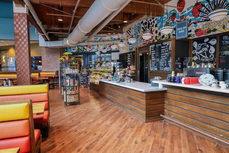 Colorful casual café interior with bright seating, murals, and counter service