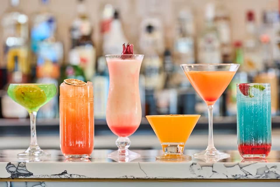Colorful cocktails on bar counter with tropical and citrus-inspired drinks