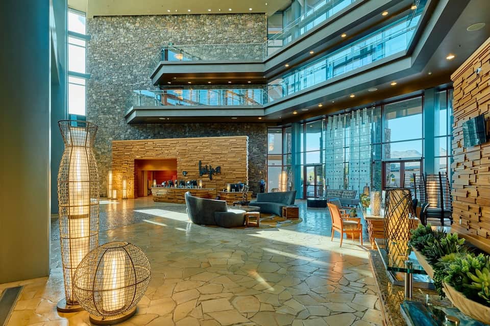 Luxury hotel lobby atrium with stone walls, modern furnishings, and large windows