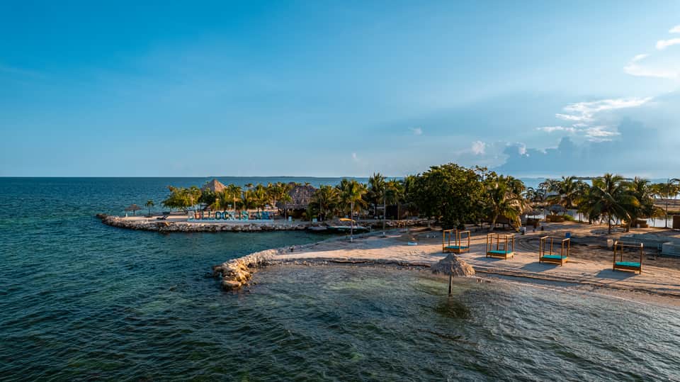 Beachfront scene with turquoise water and colorful beach swings
