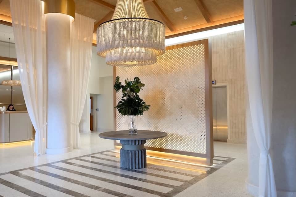 Spa reception area with beaded chandelier, neutral palette, and minimalist modern design