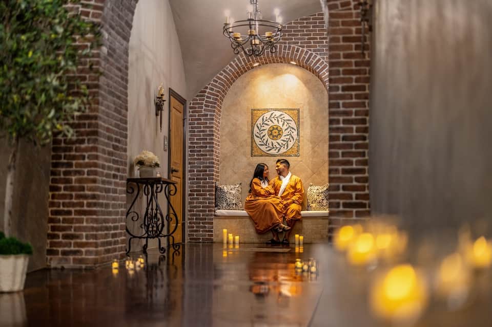 Romantic brick archway alcove with golden lighting, candles, and ornate wall decor
