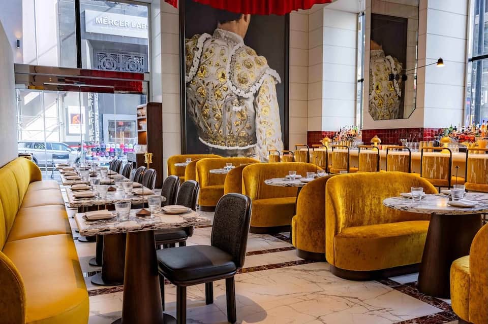 Upscale restaurant interior with golden velvet seating, marble tables, and dramatic bull artwork