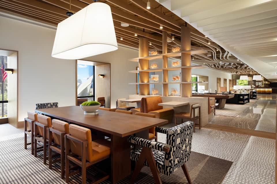 Modern hotel lobby lounge with wood furnishings, patterned chairs, and contemporary lighting