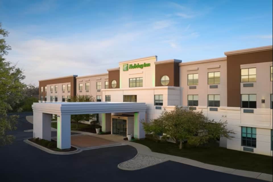 Holiday Inn hotel exterior with tan and brown brick facade and covered entrance portico