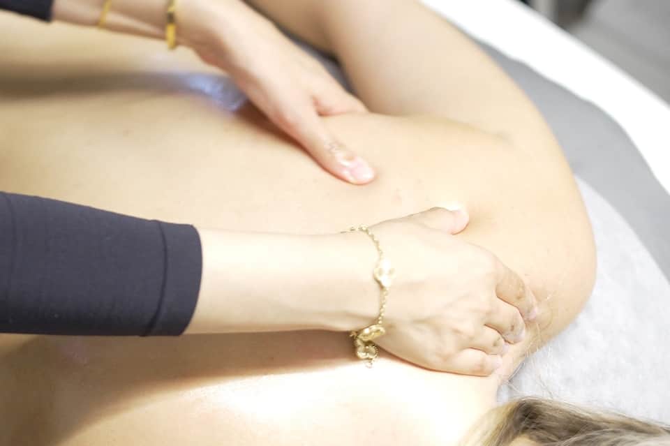 Close-up of massage therapy hands treating client's leg during spa treatment