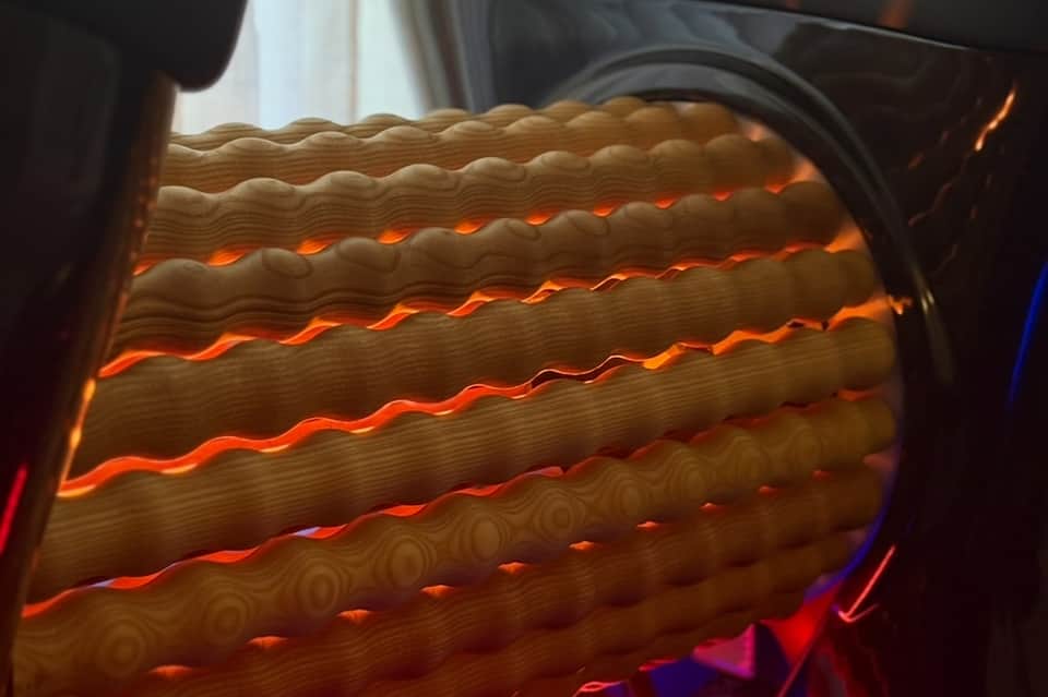 Close-up of glowing heated massage bed with orange LED lights and textured fabric surface