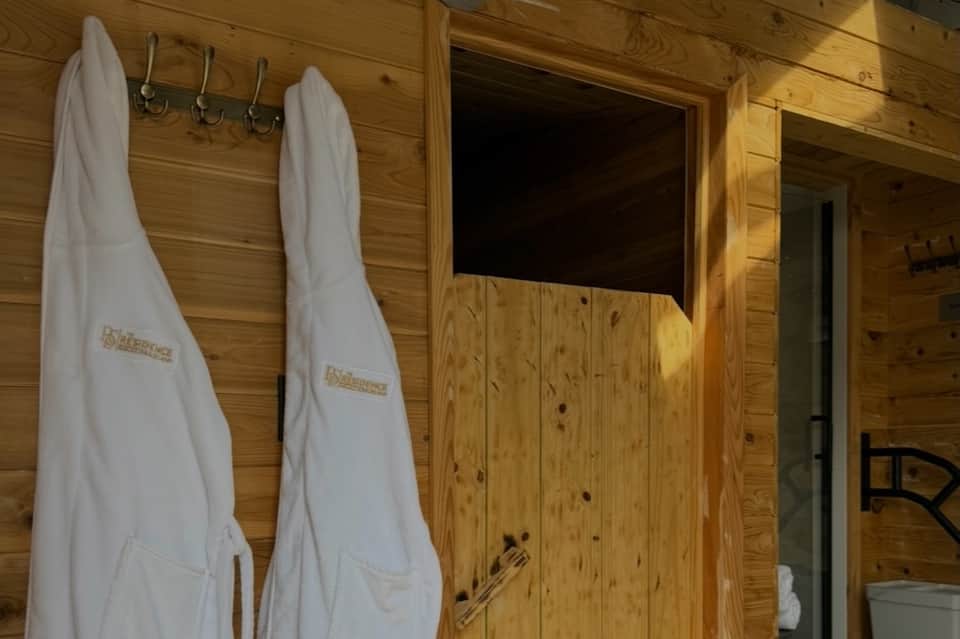 Wooden sauna interior with hanging towels and bench seating