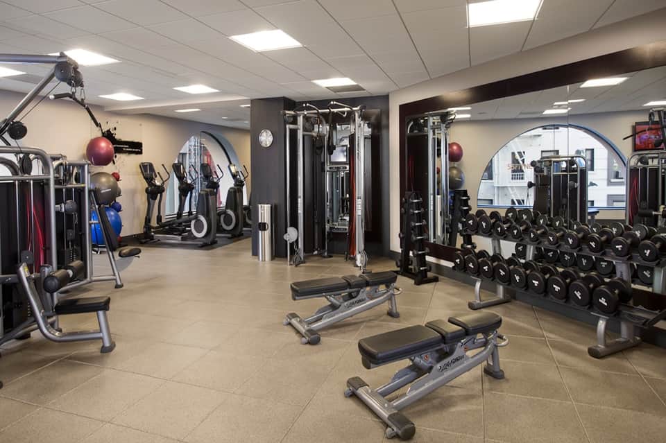 Well-equipped fitness center with cardio machines, weight racks, and strength training equipment