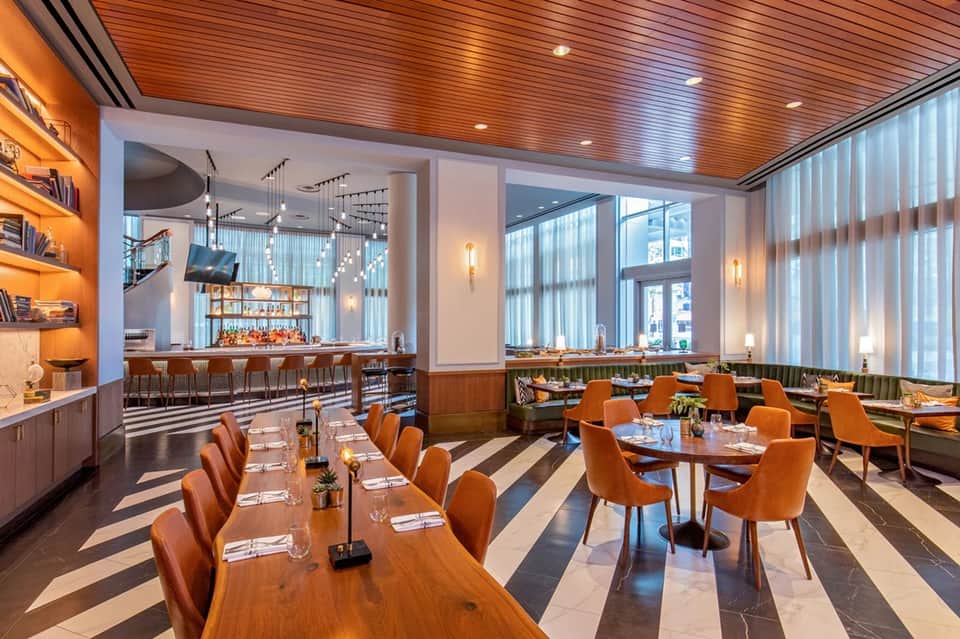Restaurant dining room with wood ceiling, bar, and city views