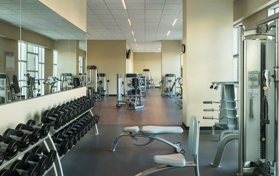 Well-equipped fitness center with dumbbells, machines, and mirrored walls